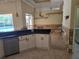 Bright kitchen featuring white cabinets, dark countertops, stainless steel appliances, and adjacent dining room at 9127 Woodridge Run Dr, Tampa, FL 33647