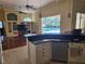Open kitchen with dark countertops, white cabinets, stainless steel appliances, and view of pool and living room at 9127 Woodridge Run Dr, Tampa, FL 33647