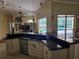 Open kitchen with dark countertops, white cabinets, stainless steel appliances, and view of the pool at 9127 Woodridge Run Dr, Tampa, FL 33647
