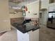 Bright kitchen featuring white cabinets, dark countertops, stainless steel appliances, and adjacent dining room at 9127 Woodridge Run Dr, Tampa, FL 33647