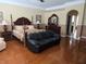 Spacious primary bedroom with hardwood floors and an elegant four-poster bed at 9127 Woodridge Run Dr, Tampa, FL 33647