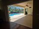 View from indoors to the screened-in pool and patio area with lush landscaping at 9127 Woodridge Run Dr, Tampa, FL 33647