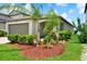 Beautifully landscaped single-story home featuring a well-manicured lawn with palm trees in the front yard at 1015 7Th Nw Ave, Ruskin, FL 33570