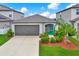 Charming single-story home featuring a well-manicured lawn and a welcoming turquoise-colored front door at 1015 7Th Nw Ave, Ruskin, FL 33570