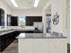 Kitchenette featuring dark cabinets, stainless steel refrigerator, granite countertops, and modern lighting fixtures at 1015 7Th Nw Ave, Ruskin, FL 33570