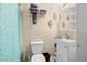 A bathroom featuring blue pattern curtain, storage, sink, toilet, and decorative accents at 1035 58Th N Ave, St Petersburg, FL 33703