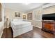 A cozy bedroom with a white platform bed, dark wood floors and window light at 1035 58Th N Ave, St Petersburg, FL 33703