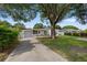 Charming single-story home featuring mature landscaping, a driveway, and an attached garage at 1035 58Th N Ave, St Petersburg, FL 33703