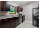 Traditional kitchen with granite countertops, dark wood cabinetry, stainless steel appliances, and a garden view at 1035 58Th N Ave, St Petersburg, FL 33703