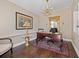 Elegant home office featuring a dark wood desk, ornate chandelier, and a marble topped side table at 1035 58Th N Ave, St Petersburg, FL 33703