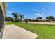 A spacious backyard features a concrete patio, lush green grass, and a picturesque waterfront view with swaying palm trees at 10449 Hunters Haven Blvd, Riverview, FL 33578