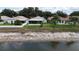 Backyard view featuring a screened-in porch, well-maintained lawn, and a peaceful pond at 10449 Hunters Haven Blvd, Riverview, FL 33578