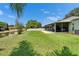 Spacious backyard with a glimpse of the screened-in patio, complete with a privacy fence and waterfront views at 10449 Hunters Haven Blvd, Riverview, FL 33578