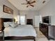 Bright primary bedroom suite with a ceiling fan, light grey walls, and dark furnishings at 10449 Hunters Haven Blvd, Riverview, FL 33578