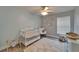 Cozy Bedroom with soft blue walls, ceiling fan, crib, rocking chair, and cloud rug at 10449 Hunters Haven Blvd, Riverview, FL 33578