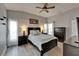 Primary bedroom suite featuring a ceiling fan, bright windows, and dark wood furnishings at 10449 Hunters Haven Blvd, Riverview, FL 33578
