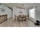 Bright dining area featuring wood floors, a modern light fixture, and easy access to kitchen at 10449 Hunters Haven Blvd, Riverview, FL 33578