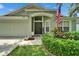 Inviting front entrance with beautiful landscaping, an American flag, and a well-lit porch at 10449 Hunters Haven Blvd, Riverview, FL 33578