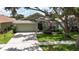 Charming single-story home with manicured lawn, an American flag, and shade trees at 10449 Hunters Haven Blvd, Riverview, FL 33578