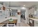 Bright eat-in kitchen nook with white bench seating and light wood-look flooring flowing into the living room at 10449 Hunters Haven Blvd, Riverview, FL 33578