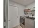 Functional laundry room with modern washer, dryer, storage shelves, and laminate flooring at 10449 Hunters Haven Blvd, Riverview, FL 33578