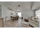 Open-concept living room and dining area featuring wood floors and stylish lighting fixture at 10449 Hunters Haven Blvd, Riverview, FL 33578