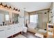 Modern bathroom featuring a double vanity, soaking tub, glass shower, and wood accents at 11121 Running Pine Dr, Riverview, FL 33569