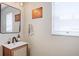 Stylish bathroom featuring a modern vanity with a dark faucet, decorative mirror, and natural light at 11121 Running Pine Dr, Riverview, FL 33569