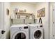 Compact laundry room features a washer, dryer, and open shelving for storage at 11121 Running Pine Dr, Riverview, FL 33569