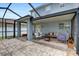 Relaxing screened-in patio with brick flooring, a fire pit, comfortable seating, and access to the backyard at 11121 Running Pine Dr, Riverview, FL 33569