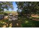 A backyard showcasing a patio set, lush green lawn, and mature trees providing ample shade at 1142 Lancer Ln, Tarpon Springs, FL 34689