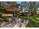 A backyard with a patio set, lush greenery, and mature trees offering shade and tranquility at 1142 Lancer Ln, Tarpon Springs, FL 34689