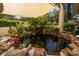 Backyard pond with rock surround and lush foliage at 1142 Lancer Ln, Tarpon Springs, FL 34689