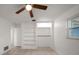 Clean bedroom featuring tiled floors, ceiling fan, built-in shelving, and a bright window at 1142 Lancer Ln, Tarpon Springs, FL 34689