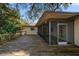 A partially covered wooden deck with a screened patio and a backyard view with lush landscaping at 1142 Lancer Ln, Tarpon Springs, FL 34689