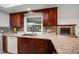 Stylish kitchen featuring granite countertops, a window over the sink, and dark wood cabinets at 1142 Lancer Ln, Tarpon Springs, FL 34689