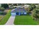 Aerial view of a newly renovated house with a spacious, green front lawn and modern features at 11635 Willmington Blvd, Port Charlotte, FL 33981