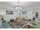 Bright living room featuring coastal decor, light wood floors, modern lighting, and outdoor access at 11635 Willmington Blvd, Port Charlotte, FL 33981