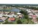 Aerial view of homes surrounding a scenic pond, offering a picturesque neighborhood setting at 1201 Peridot Ln, Sun City Center, FL 33573