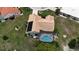 Aerial view of a beautiful home featuring a screened-in pool, well-maintained landscaping and solar panels at 1201 Peridot Ln, Sun City Center, FL 33573