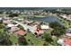 Aerial view of the home with a pool, manicured lawn, and a nearby lake at 1201 Peridot Ln, Sun City Center, FL 33573