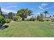Expansive backyard with lush lawn, mature trees, and manicured landscaping at 1201 Peridot Ln, Sun City Center, FL 33573