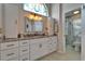 Bright bathroom features granite counters, white cabinets, and a stylish mirror with a decorative window at 1201 Peridot Ln, Sun City Center, FL 33573
