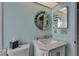 Bathroom features updated vanity, a marble top, and a round mirror at 1201 Peridot Ln, Sun City Center, FL 33573