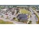 Aerial view of community center with lawn bowling, large parking lot, and meticulously maintained lawns at 1201 Peridot Ln, Sun City Center, FL 33573