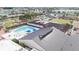 Aerial view of large community pool with lounge chairs, tables, umbrellas, and manicured lawns at 1201 Peridot Ln, Sun City Center, FL 33573