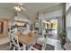 Open-concept dining area with a table for six and views of the kitchen and backyard patio at 1201 Peridot Ln, Sun City Center, FL 33573