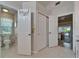 Bright hallway features tile floor, a closet, and doorways into the bathroom and lanai at 1201 Peridot Ln, Sun City Center, FL 33573