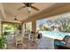Spacious screened lanai with ample seating, ceiling fans, and views of the pool and landscaping at 1201 Peridot Ln, Sun City Center, FL 33573