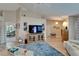 Spacious living room with hardwood floors, a large television, and ample seating at 1201 Peridot Ln, Sun City Center, FL 33573